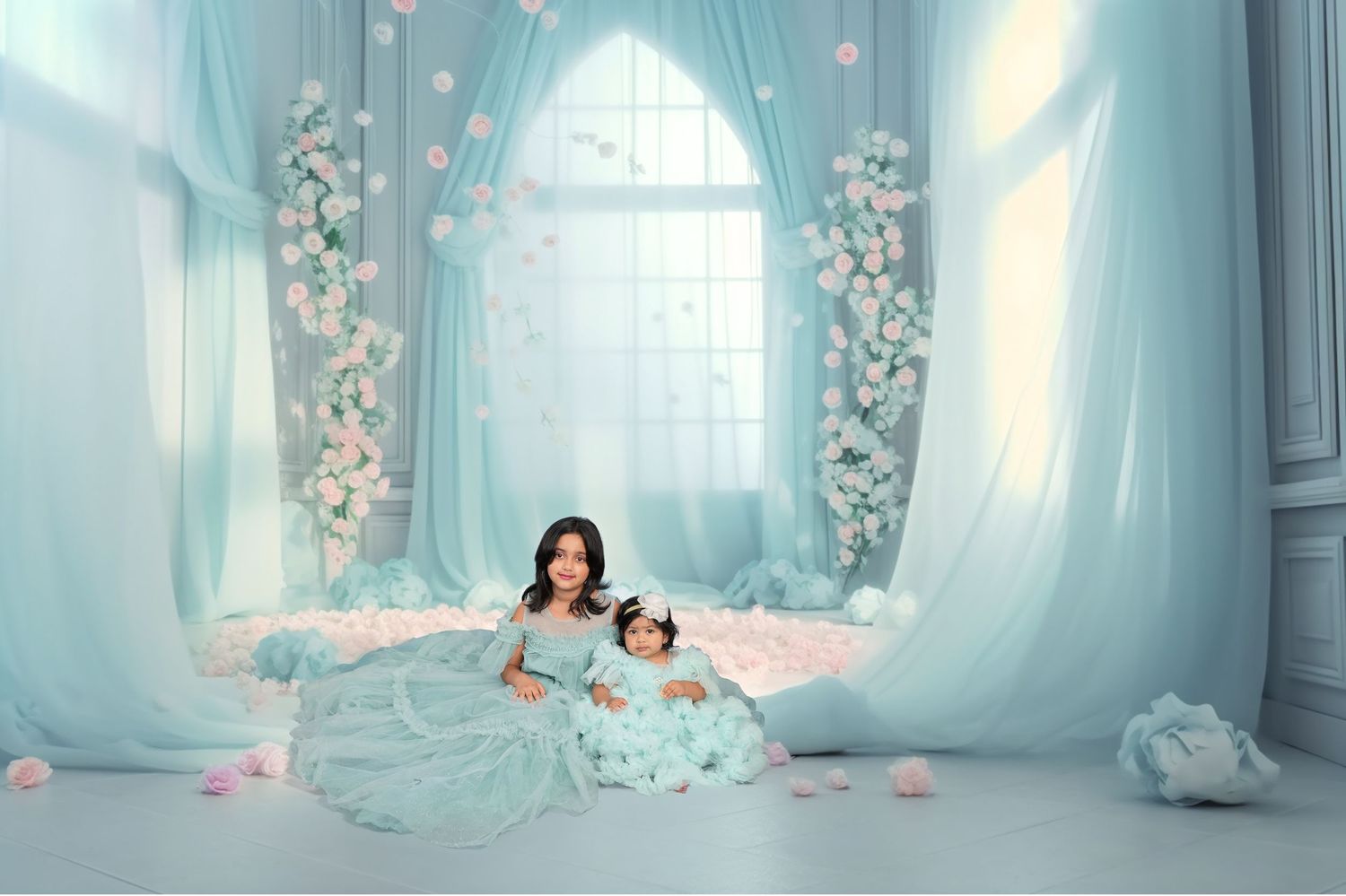 A person in a pink dress poses gracefully in an ethereal blue room with floating flower petals and wispy curtains.
