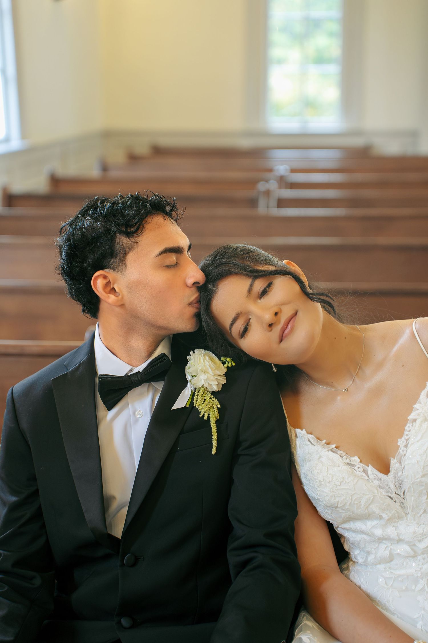 groom kissing bride's head at their intimate chapel wedding in Virginia