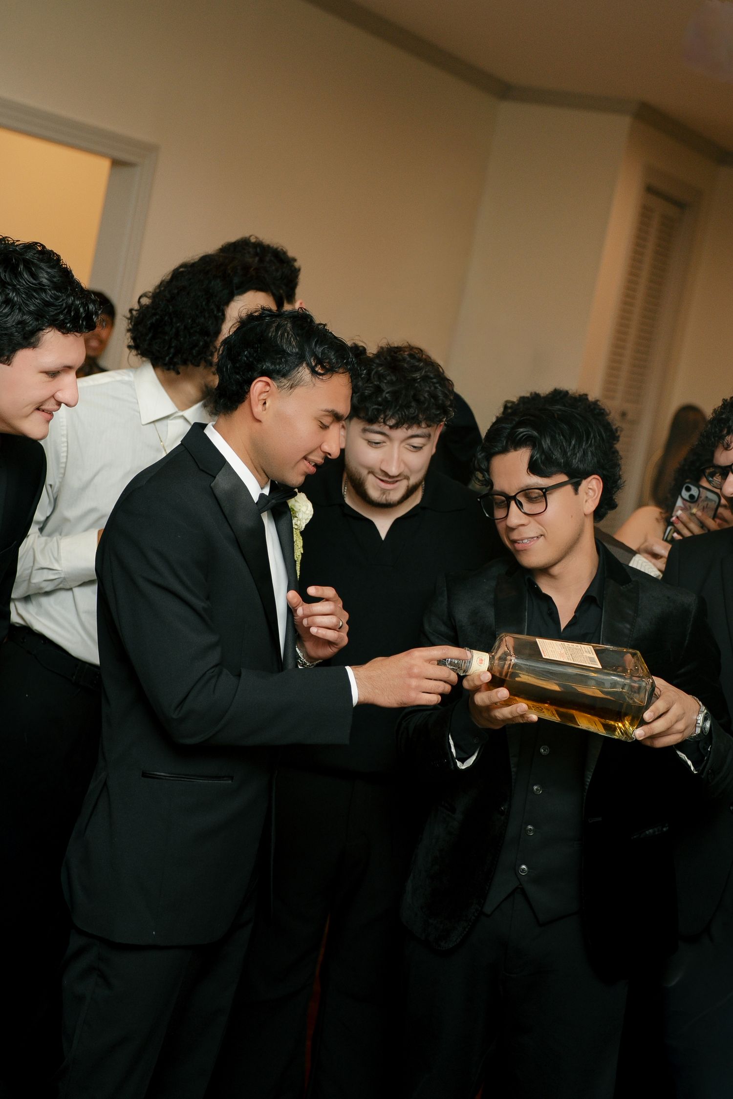 groom and his groomsmen pouring drinks during his fun reception time