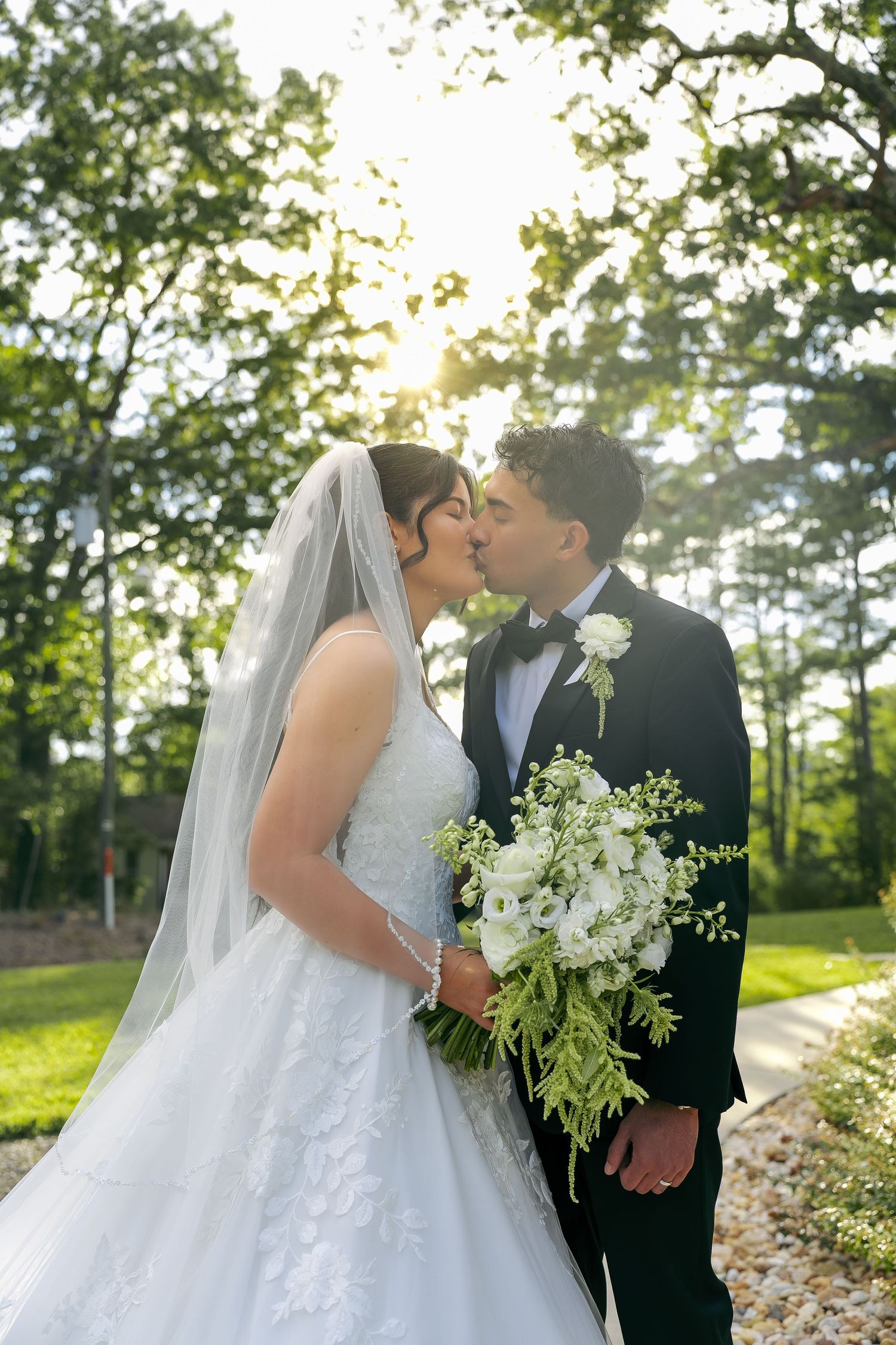 A beautiful bride and groom portrait taken outside during sunset while holding a gorgeous bouquet