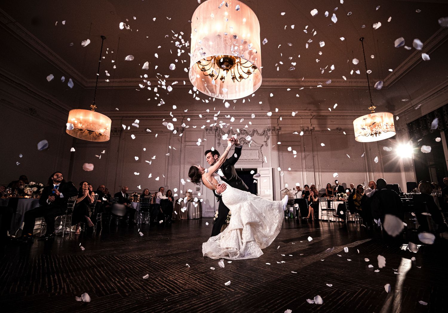 A romantic wedding dance scene in a grand ballroom with floating lanterns and confetti creating a magical atmosphere.