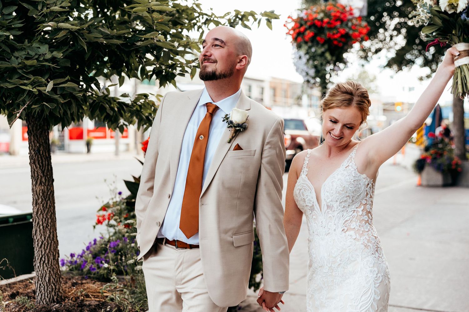 A celebratory moment captured as a couple walks outdoors in wedding attire.