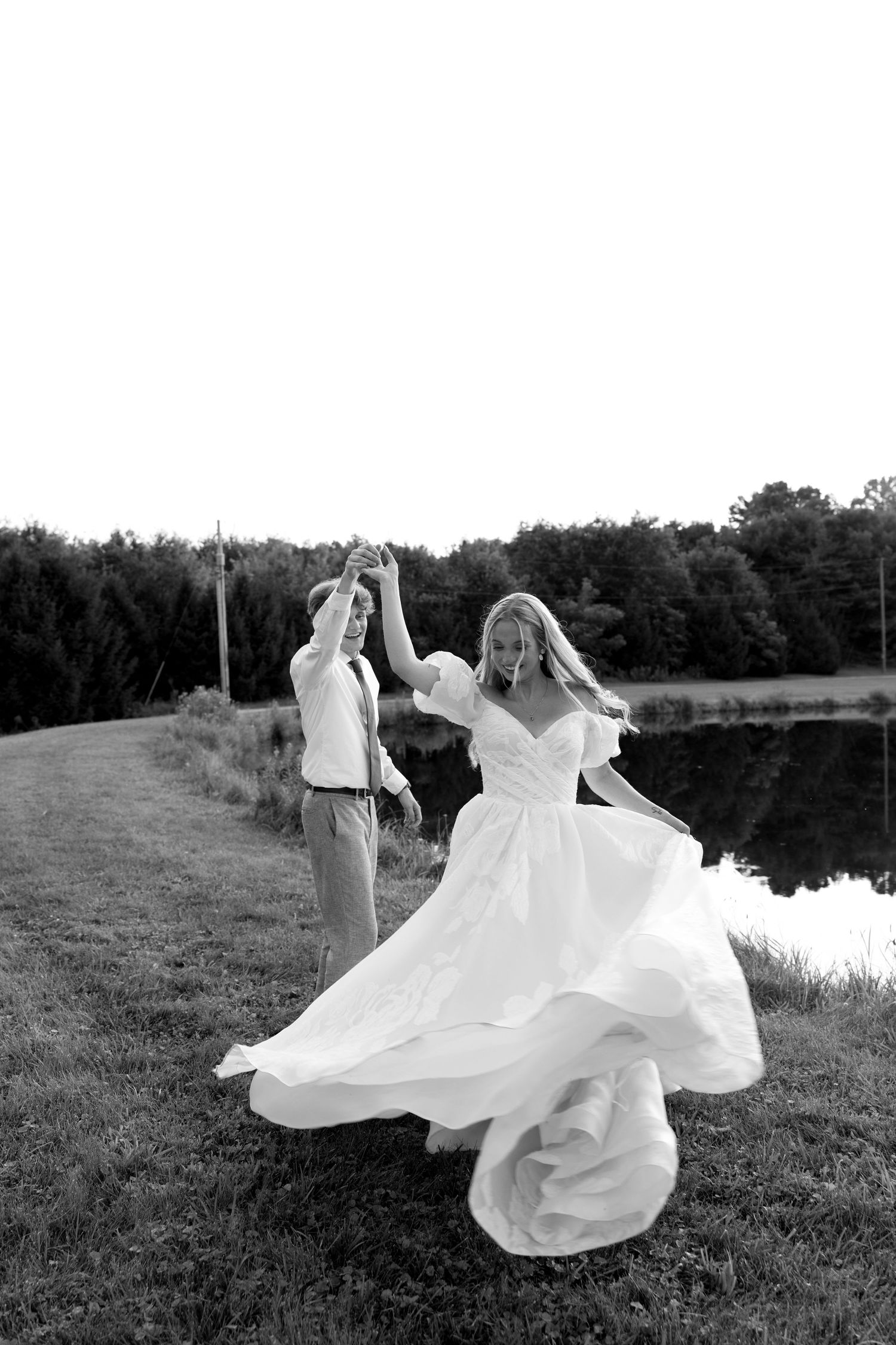 A series of black and white photos showing a flowing white wedding dress twirling in motion by a lake.