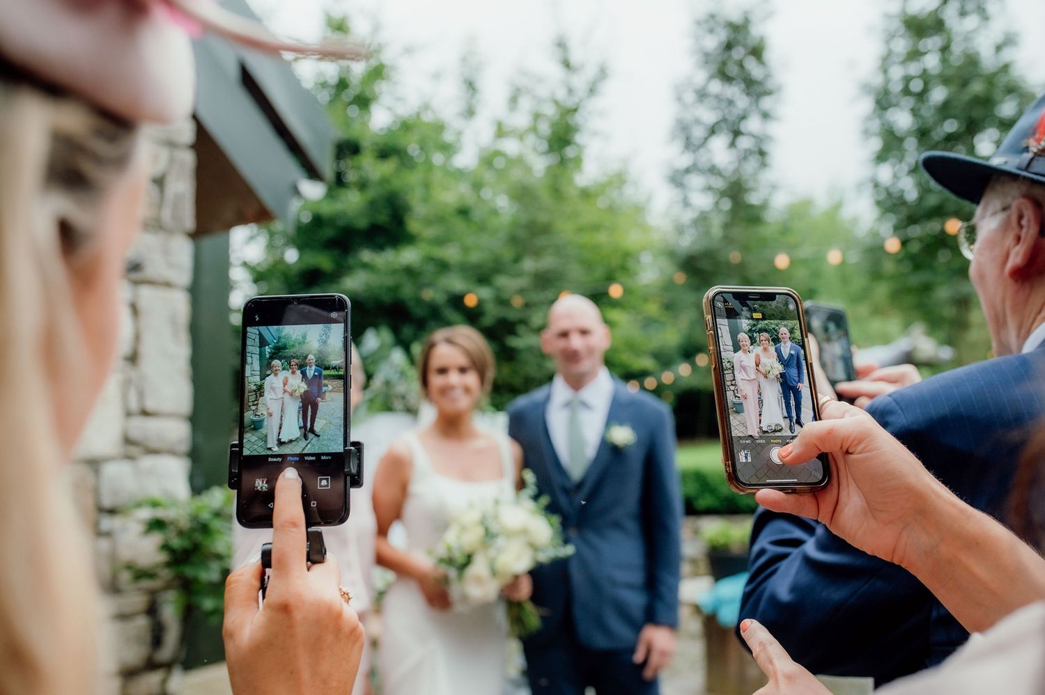 Westmeath wedding photographer capturing bride and groom with guests using smartphones.
