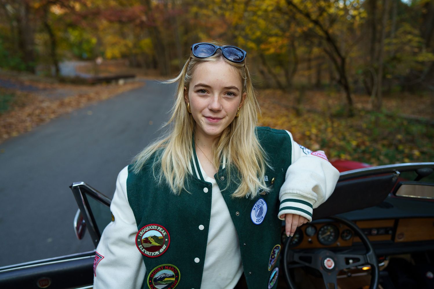 High school senior girl wearing a varsity jacket outdoors in Columbus, Ohio, photographed by Jamie Macey Photography