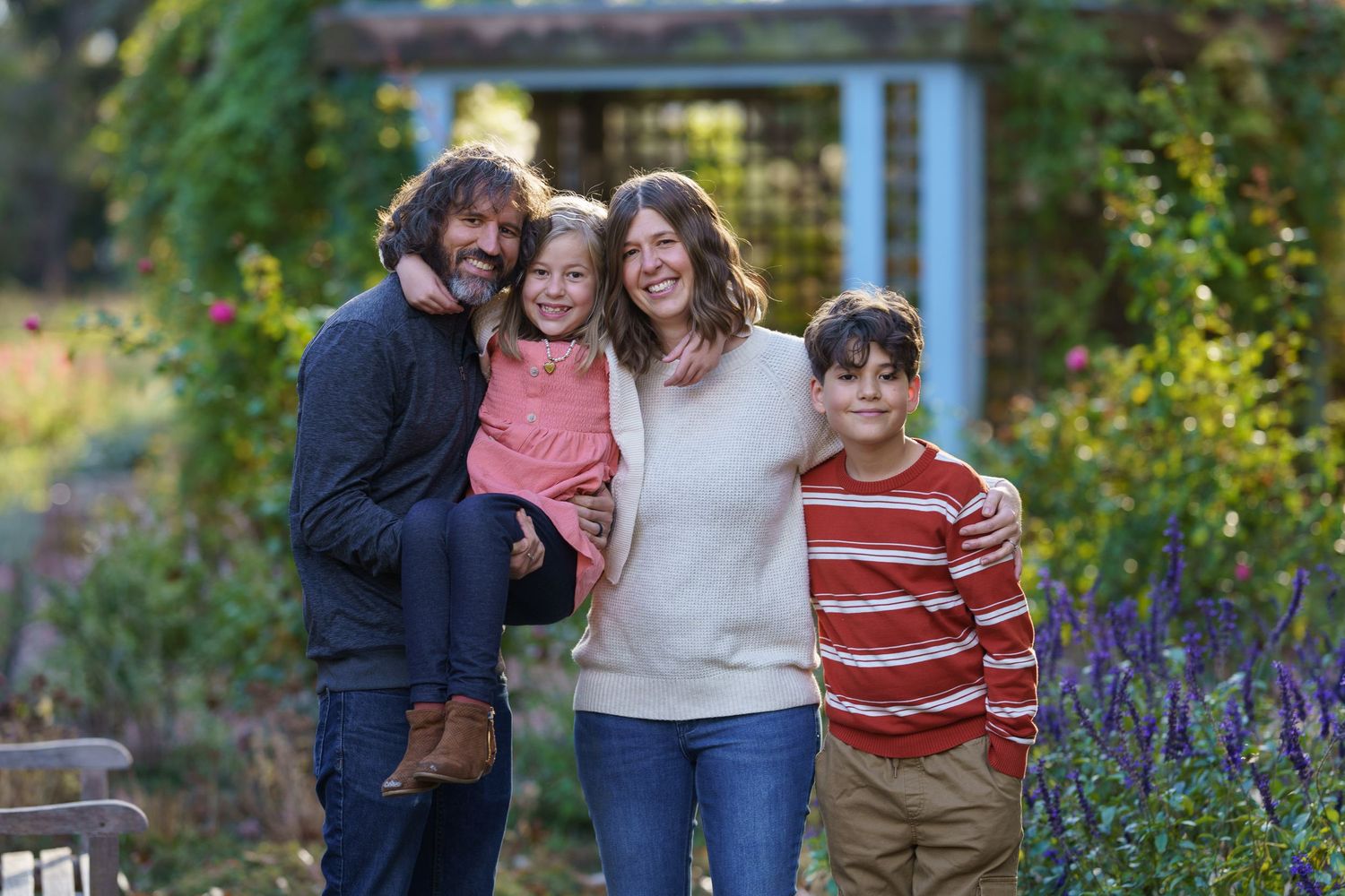 Family of four posing together in a flower garden in Columbus, Ohio, photographed by Jamie Macey Photography