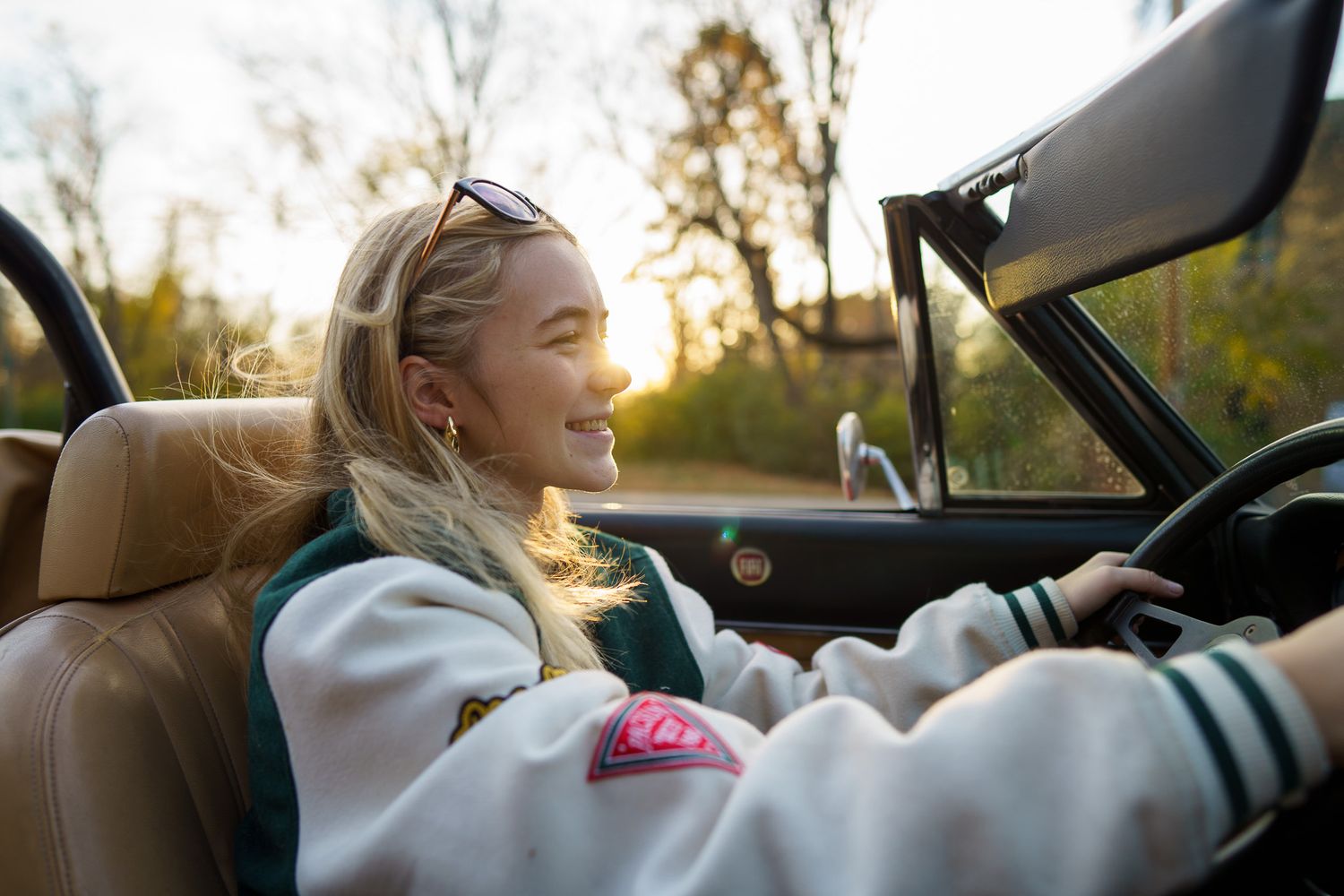 High school senior girl laughing beside a convertible in Columbus, Ohio, photographed by Jamie Macey Photography