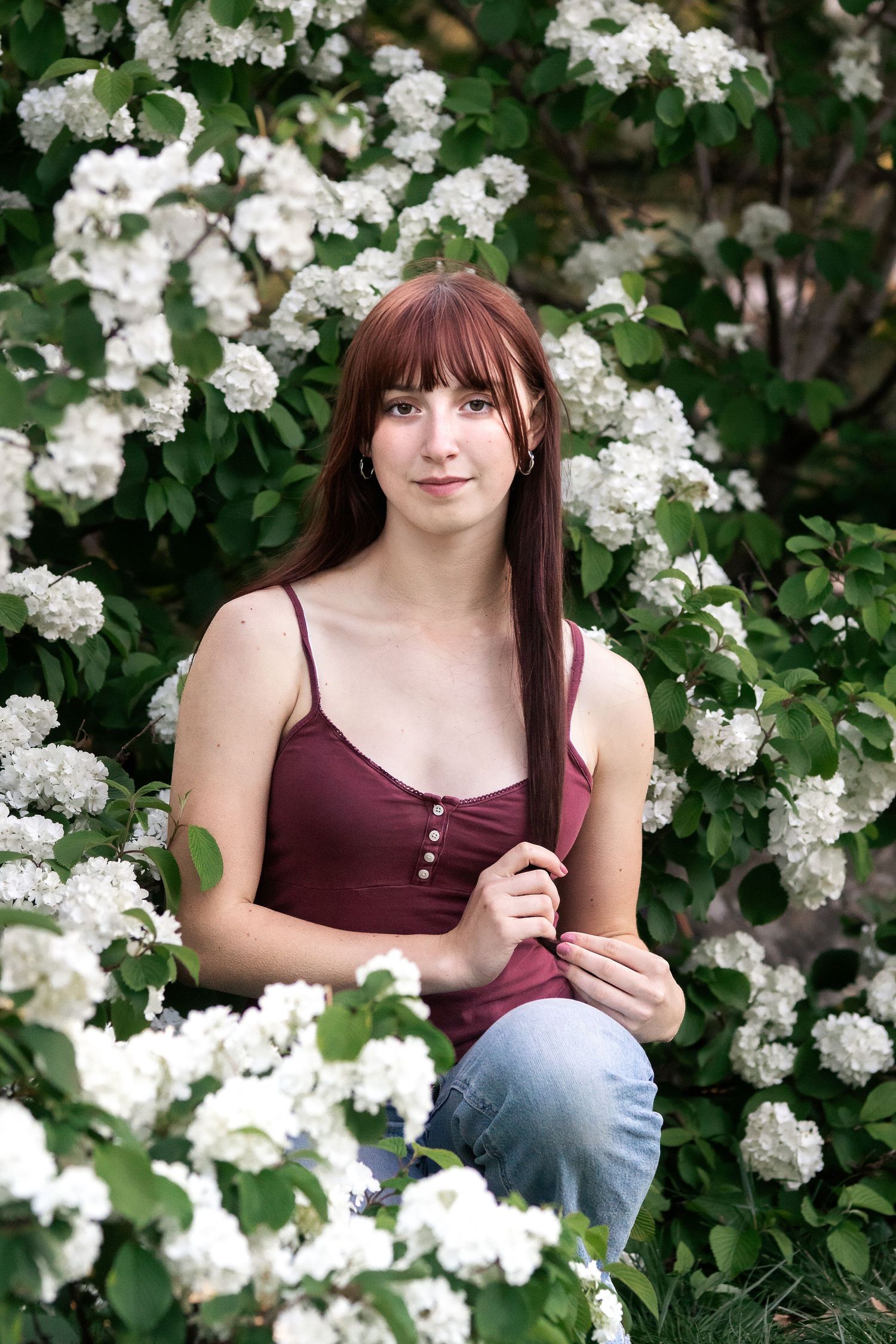 High school senior girl surrounded by white flowers in Columbus, Ohio, photographed by Jamie Macey Photography