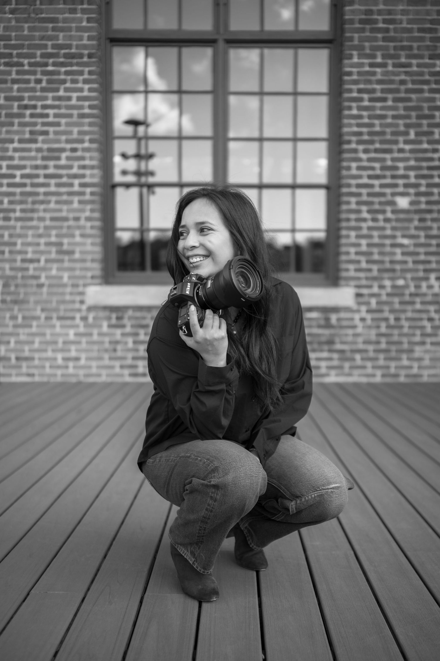 Black and white photo series showing a person in dark clothing crouching on a wooden deck against a brick wall.