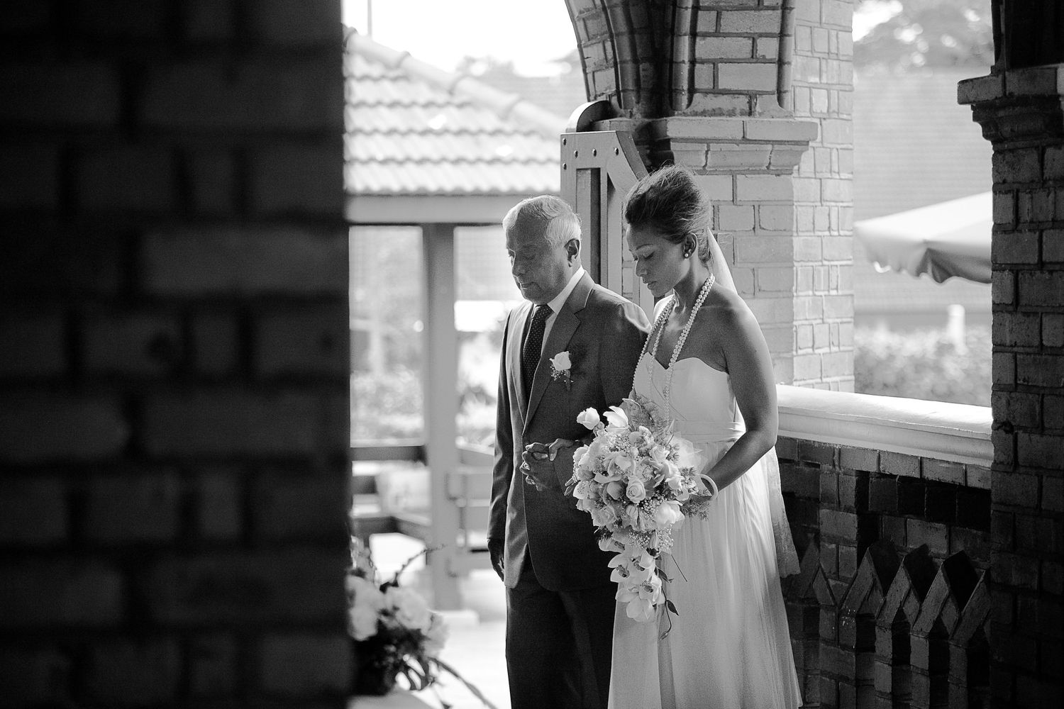 Wedding couple posing against brick walls in an urban setting.