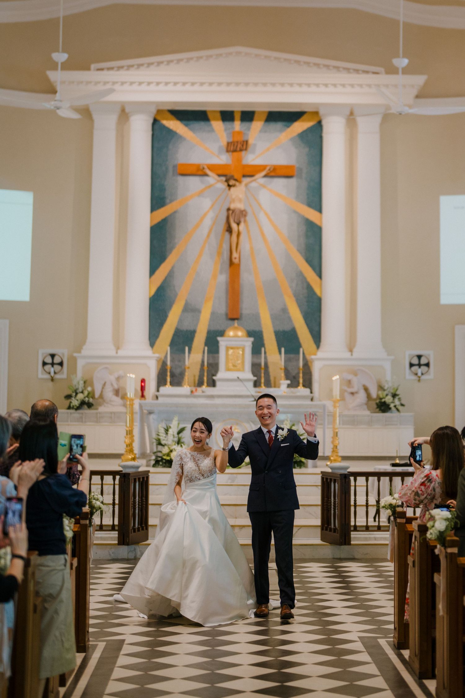 Church ceremony with black and white checkered floor and golden sunburst altar design.