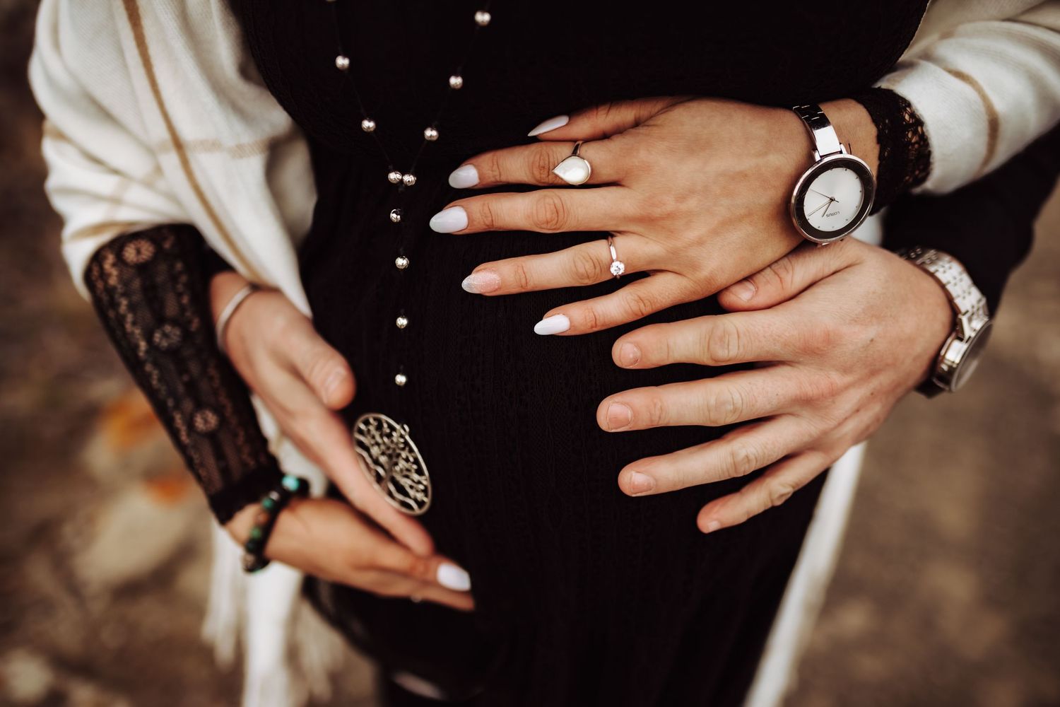 A pregnant belly being cradled by husband and wife, photographed by Kristy Baker Photography in Steamboat Springs, Colorado.