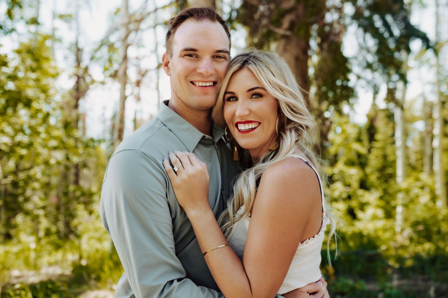A couple smiling after their surprise engagement, photographed by Kristy Baker Photography in Steamboat Springs, Colorado.