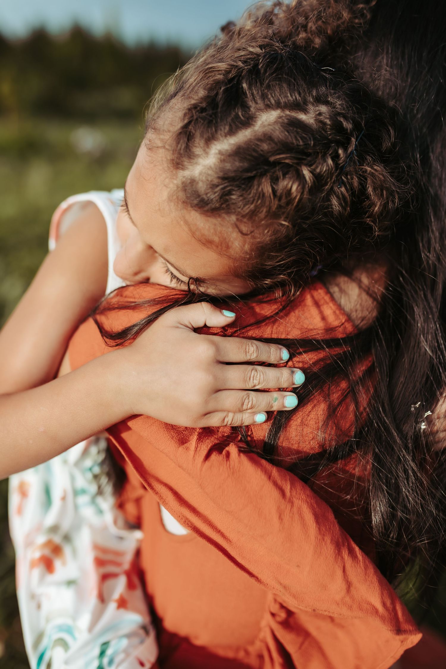 A young girl is being held by her mother, photographed by Kristy Baker Photography.