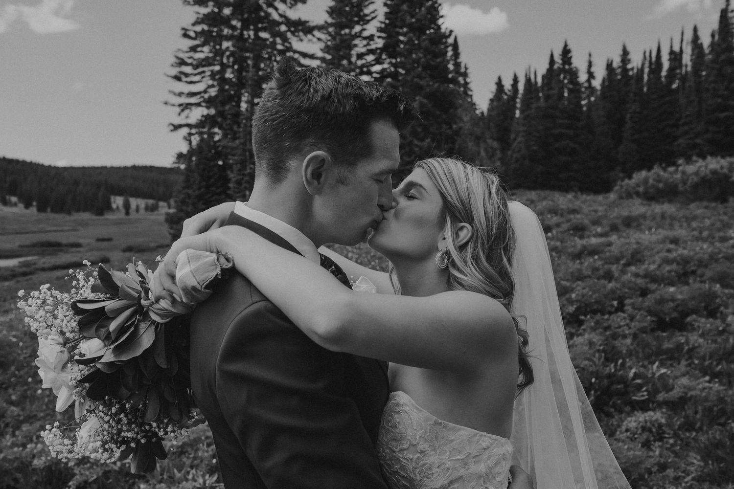 A couple kiss each other after just getting married, photographed by Kristy Baker Photography in Steamboat Springs, Colorado.