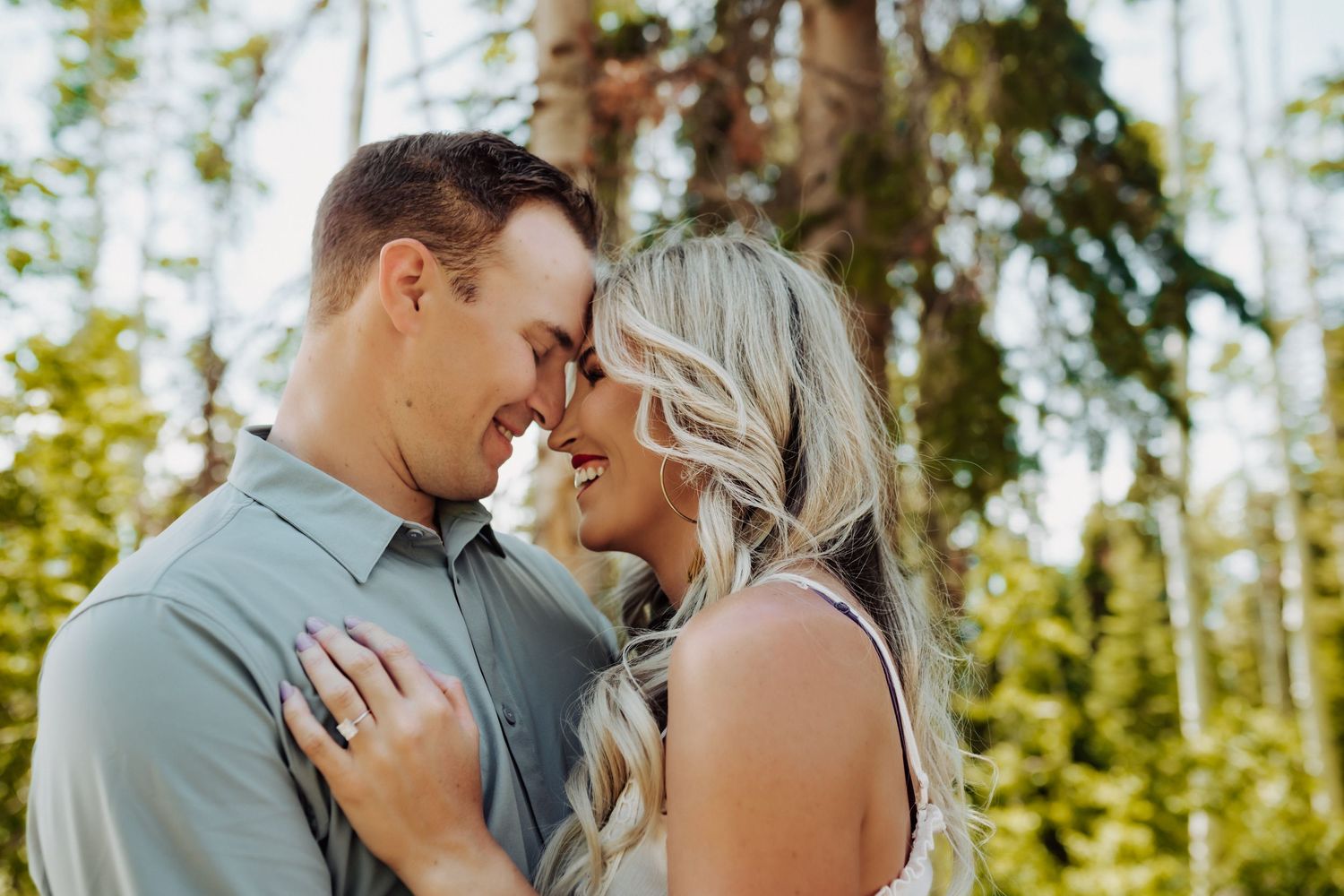 A happy couple smiling and leaning their heads together, photographed by Kristy Baker Photography in Steamboat Springs, Colorado.