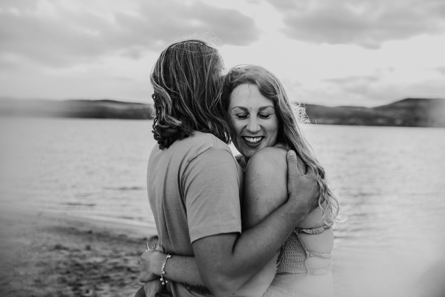 A couple embracing each other by the water, photographed by Kristy Baker Photography in Steamboat Springs, Colorado.