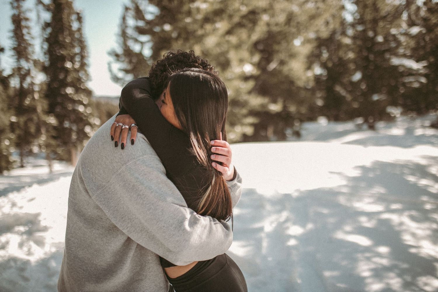 A couple embracing each other in the forrest during the winter, photographed by Kristy Baker Photography in Steamboat Springs, Colorado.