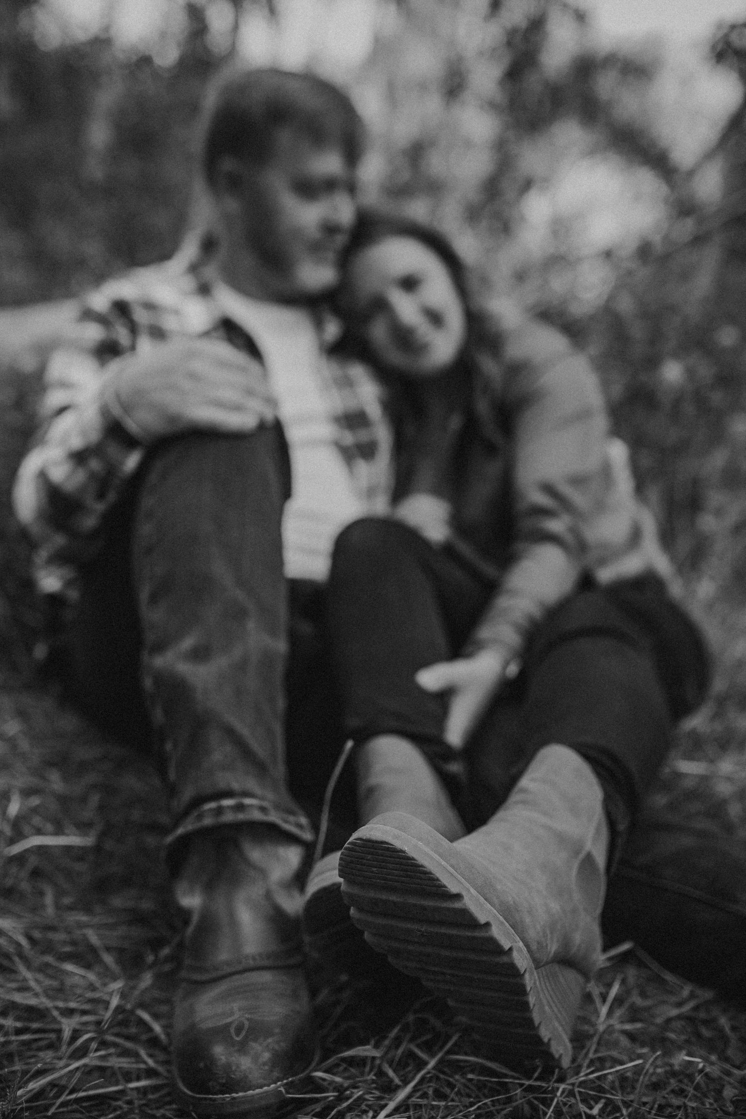 A couple sitting on the ground leaning into each other, photographed by Kristy Baker Photography in Steamboat Springs, Colorado.