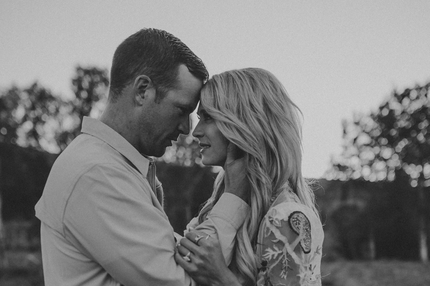 A couple touching foreheads and looking deeply into each other's eyes, photographed by Kristy Baker Photography.