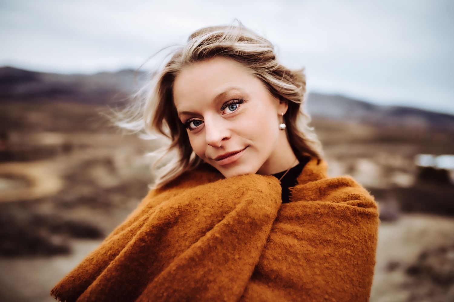 A woman hugs her shawl and looks deep into the camera, photographed by Kristy Baker Photography in Steamboat Springs, Colorado.
