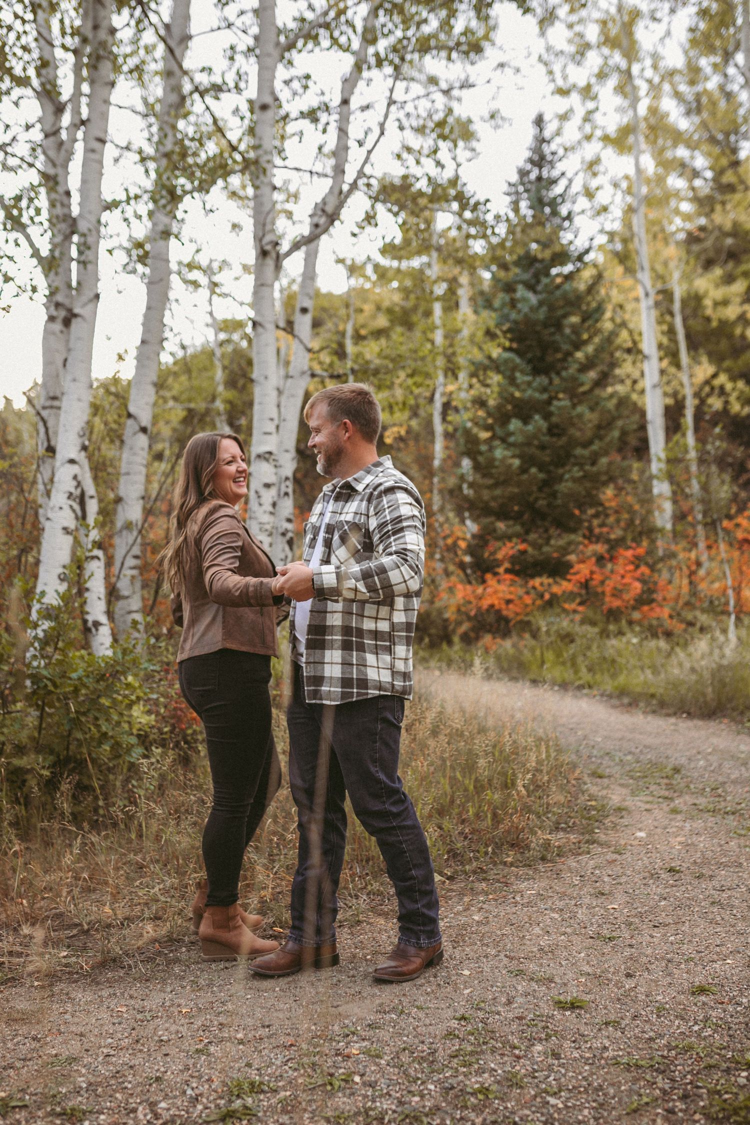 A couple dancing on a trail by aspen trees in the fall, photographed by Kristy Baker Photography in Steamboat Springs, Colorado.