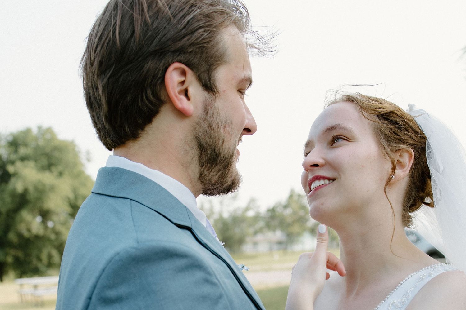 Romantic couple portrait outside family church in Oklahoma, taken by professional Oklahoma wedding photographer