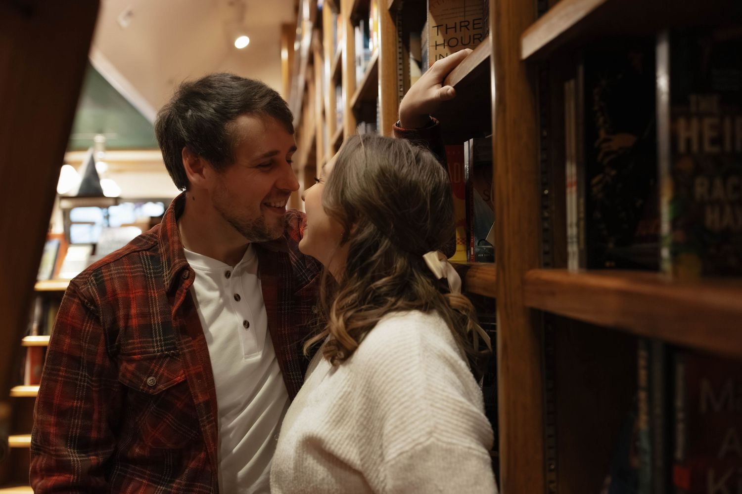 Romantic bookstore engagement photos in Oklahoma City with a couple surrounded by books