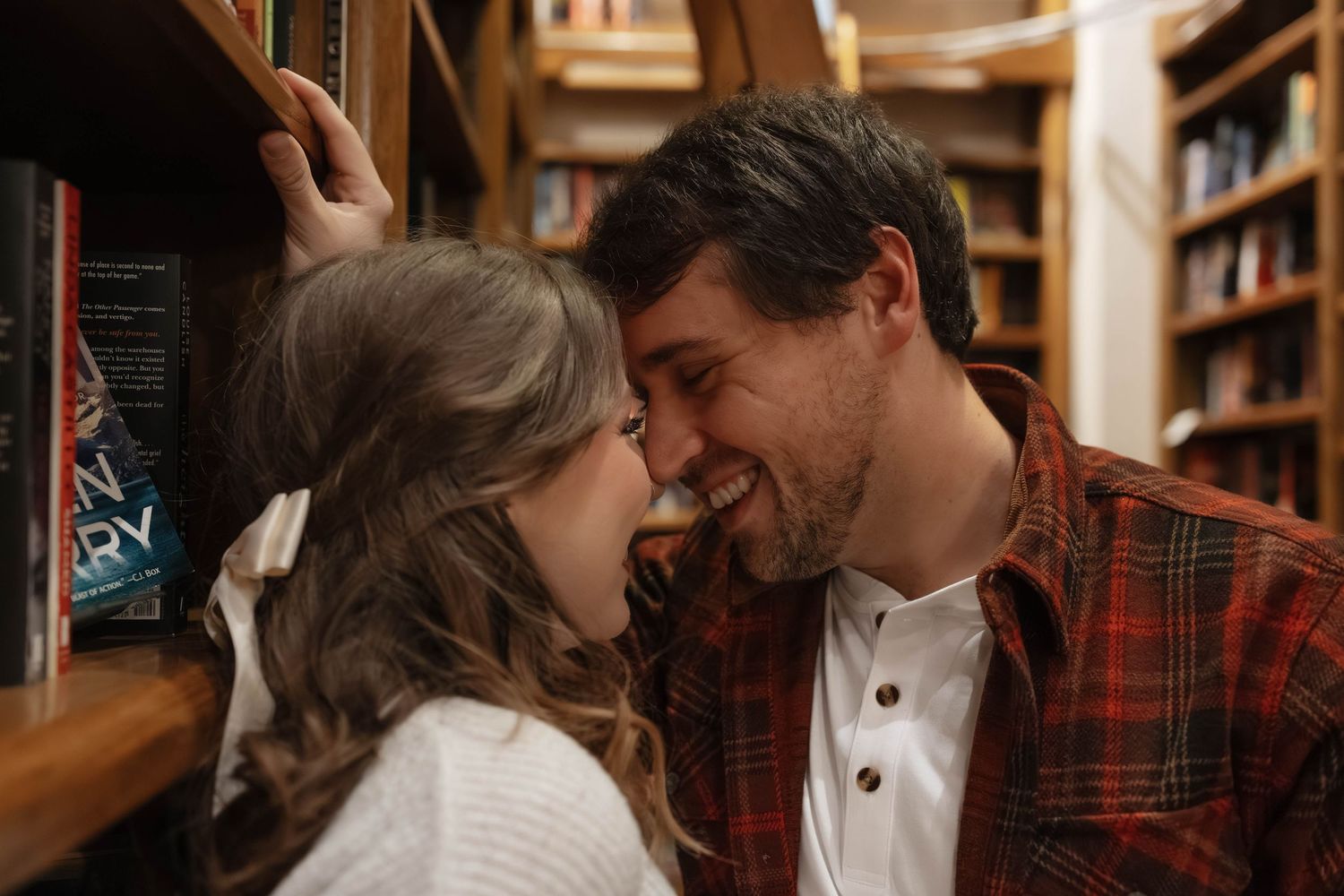 Romantic bookstore engagement photos in Oklahoma City with a couple surrounded by books