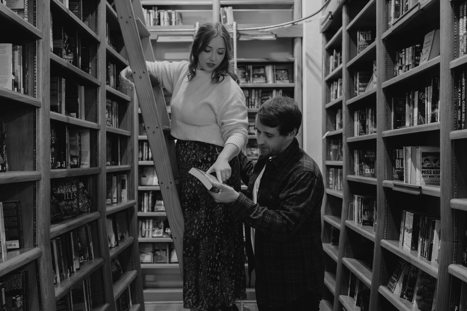Romantic bookstore engagement photos in Oklahoma City with a couple surrounded by books
