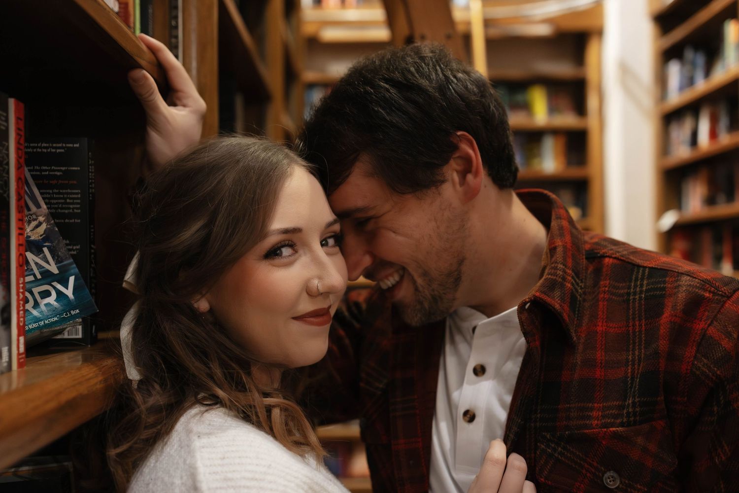 Romantic bookstore engagement photos in Oklahoma City with a couple surrounded by books