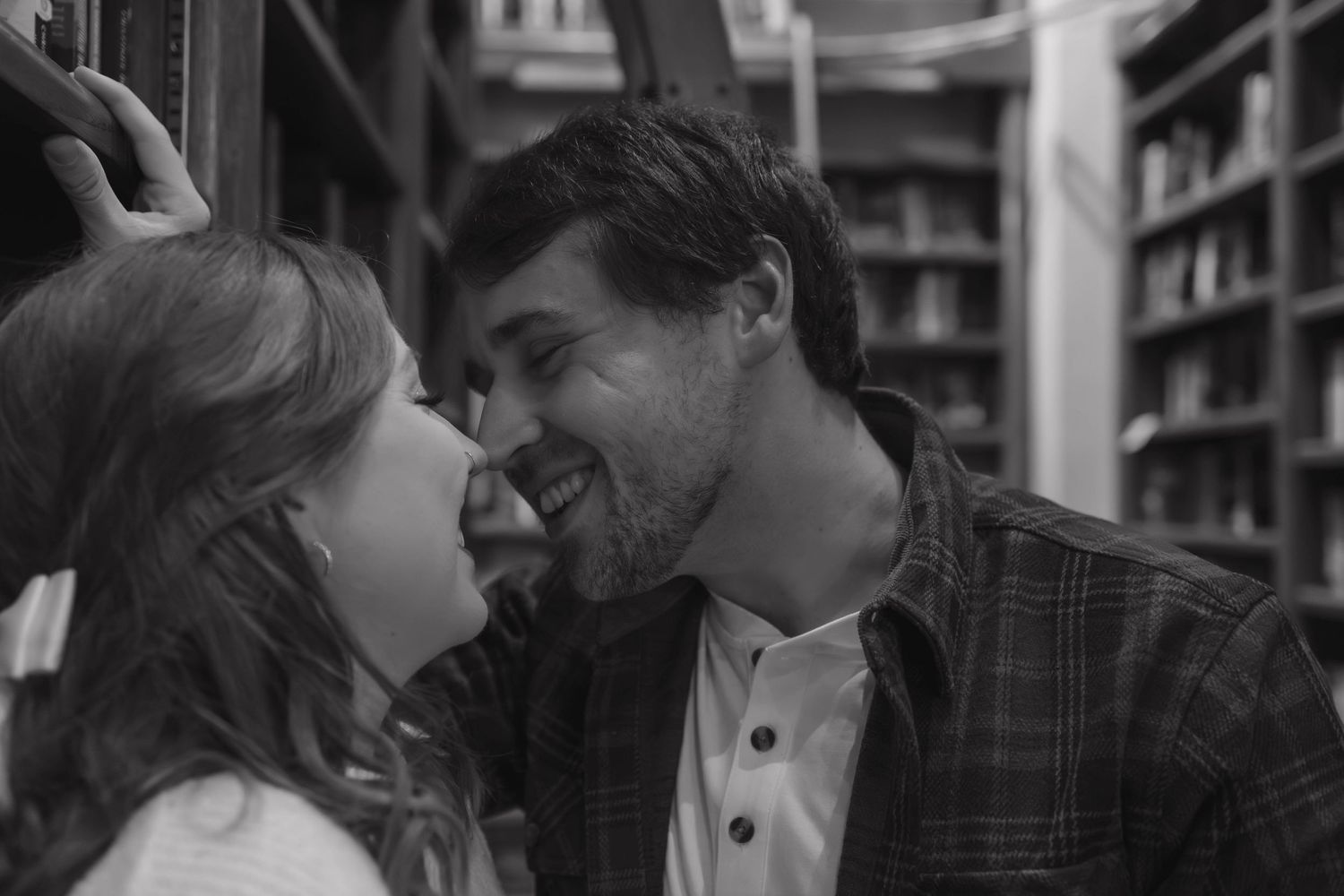 Romantic bookstore engagement photos in Oklahoma City with a couple surrounded by books