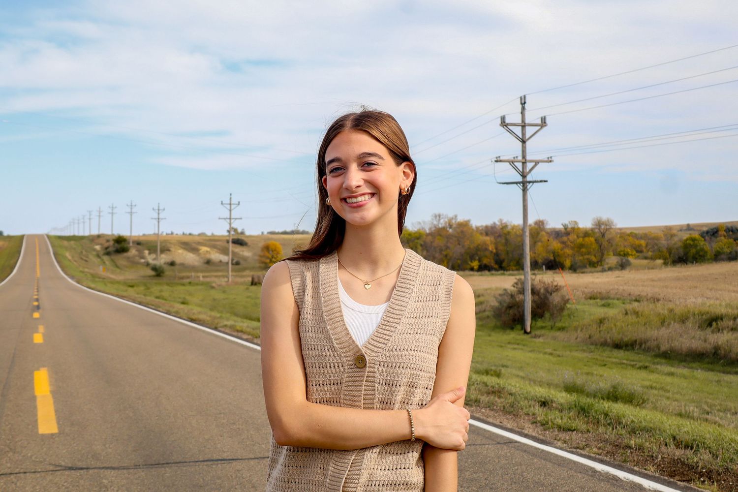 Dickinson photographer North Dakota senior portrait with natural smile, wind in hair, and warm outdoor light.