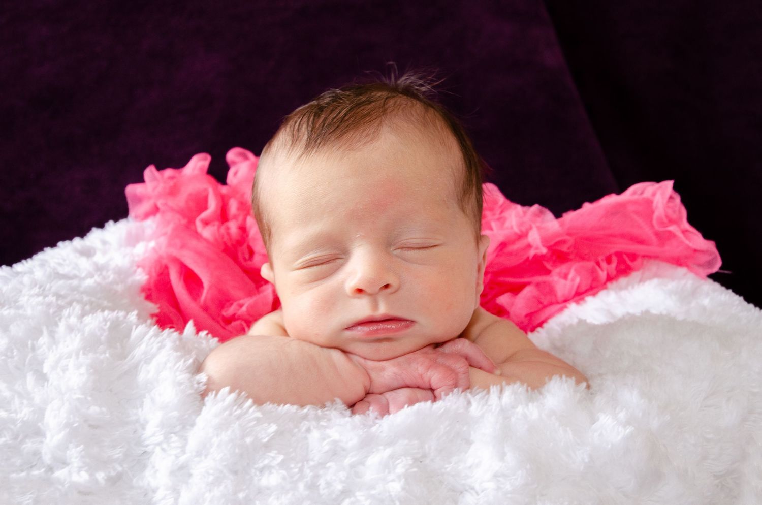 Newborn photography session in Davis County featuring a baby in a cozy, natural setting capturing soft, timeless and emotional moments
