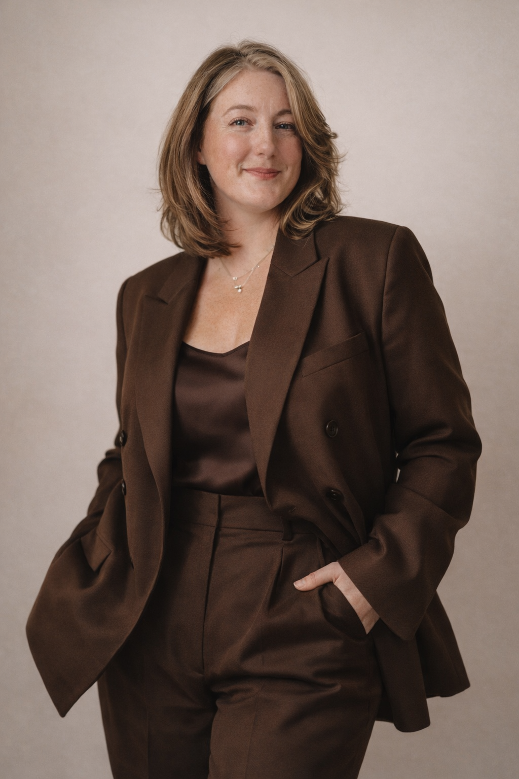 Professional studio portraits showing various poses in a brown business suit.