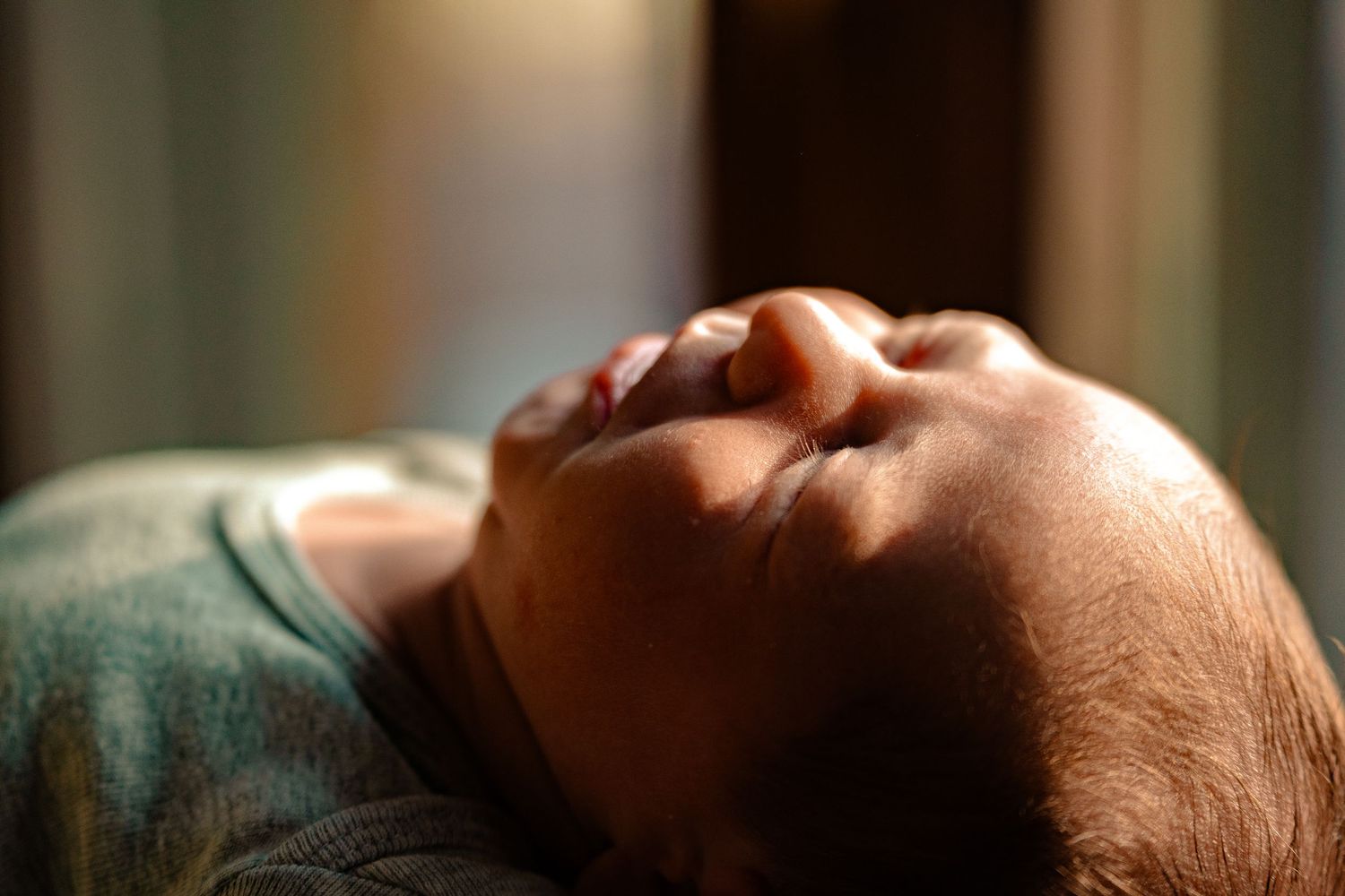 Close-up of peaceful sleeping newborn baby in soft warm light.