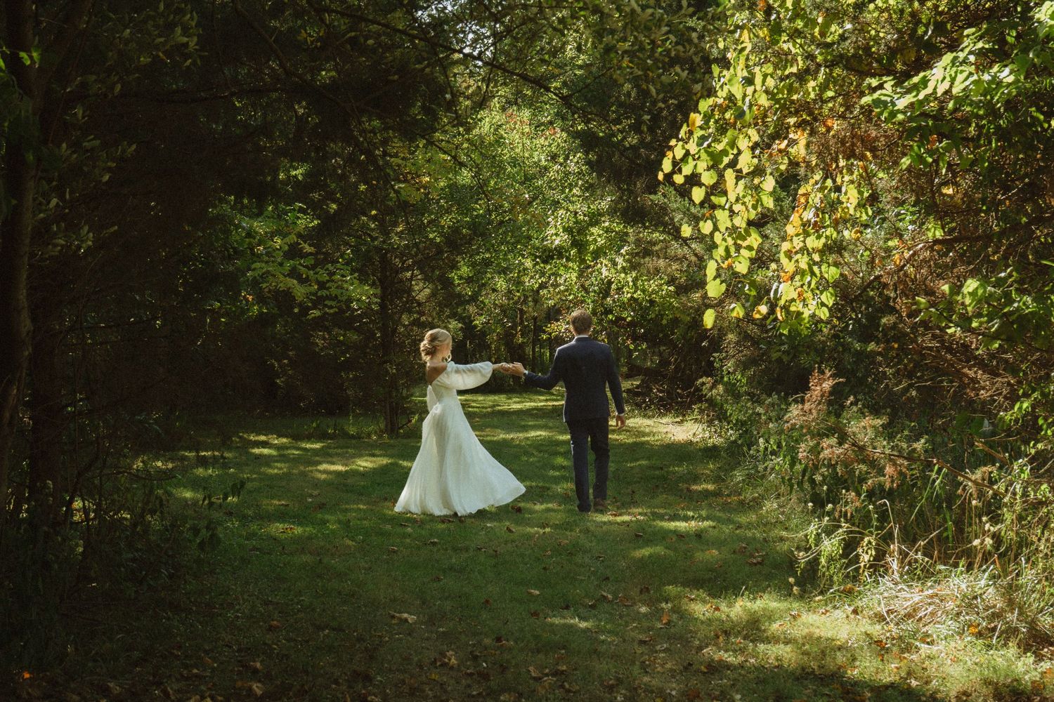 Garden wedding scene with natural sunlight filtering through trees.