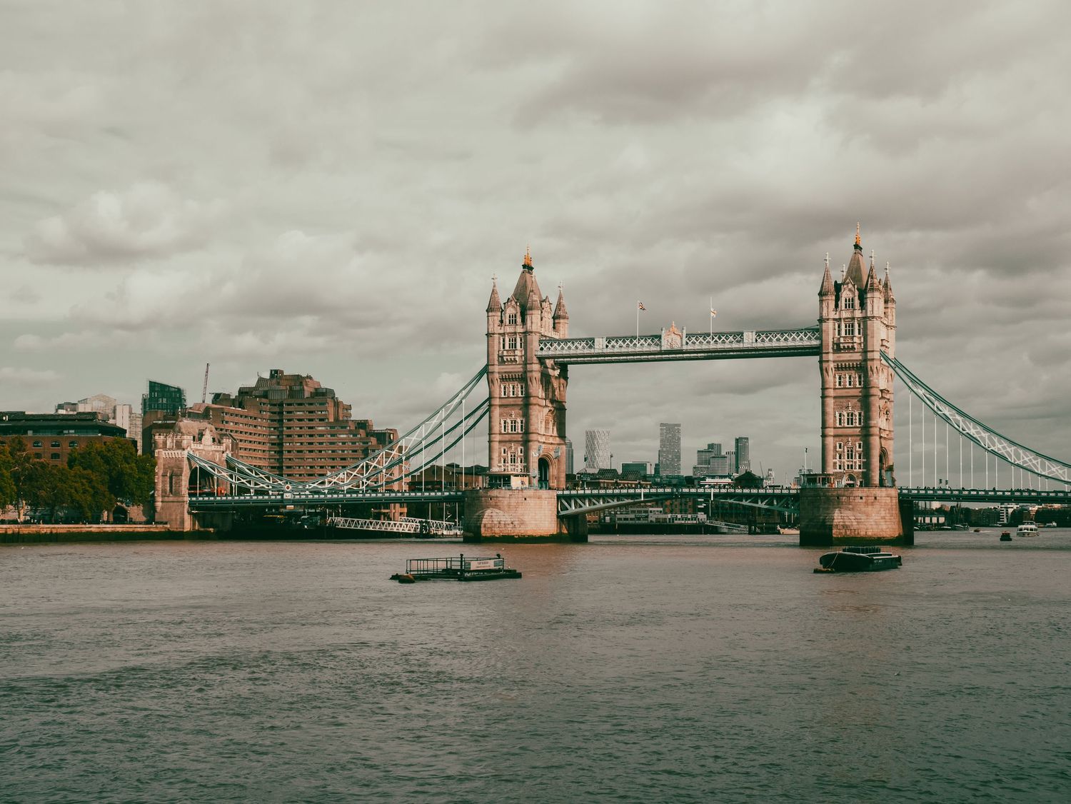 L'iconico Tower Bridge di Londra visto dal Tamigi sotto un cielo nuvoloso. Iconic Tower Bridge over River Thames, cloudy sky. MEvisual