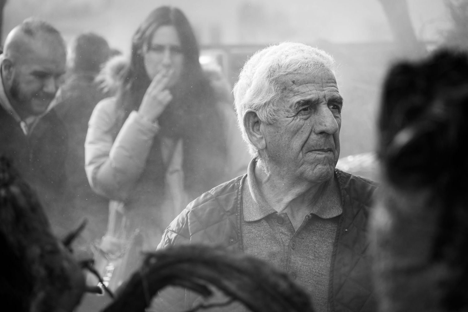Traditional Mamuthones and Issohadores masks around the fire in Mamoiada, Sardinia - Black and white reportage by Marco Eretta