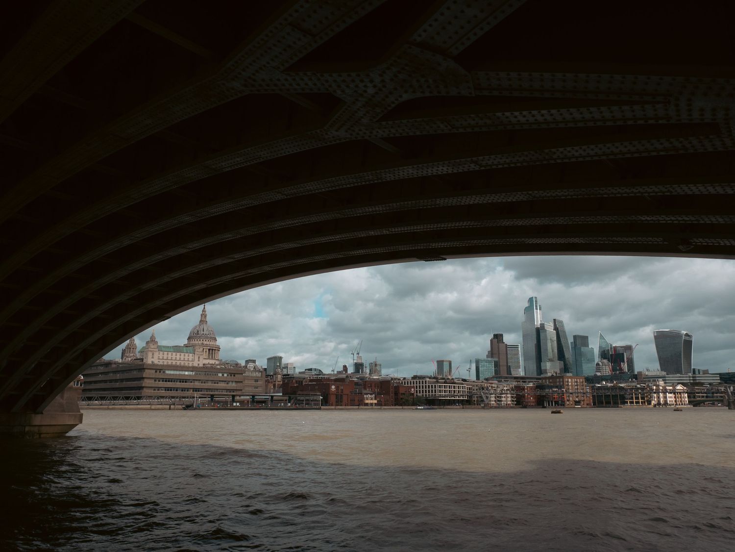 Skyline di Londra incorniciato da un arco scuro del ponte sul Tamigi. London skyline framed by bridge arch, St Paul's. MEvisual Marco Eretta