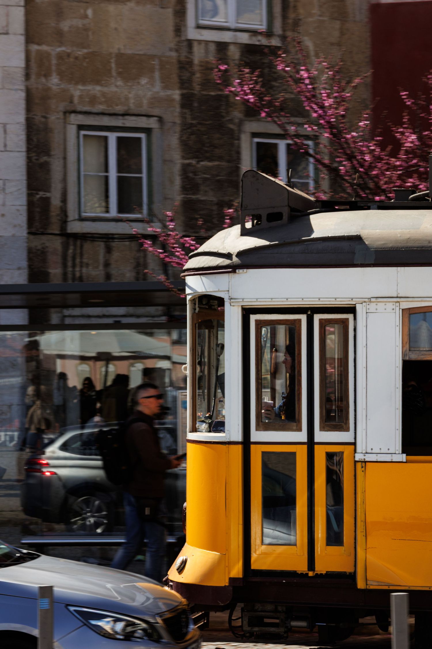 Tram storico giallo tra i vicoli dell'Alfama a Lisbona - Luce del mattino