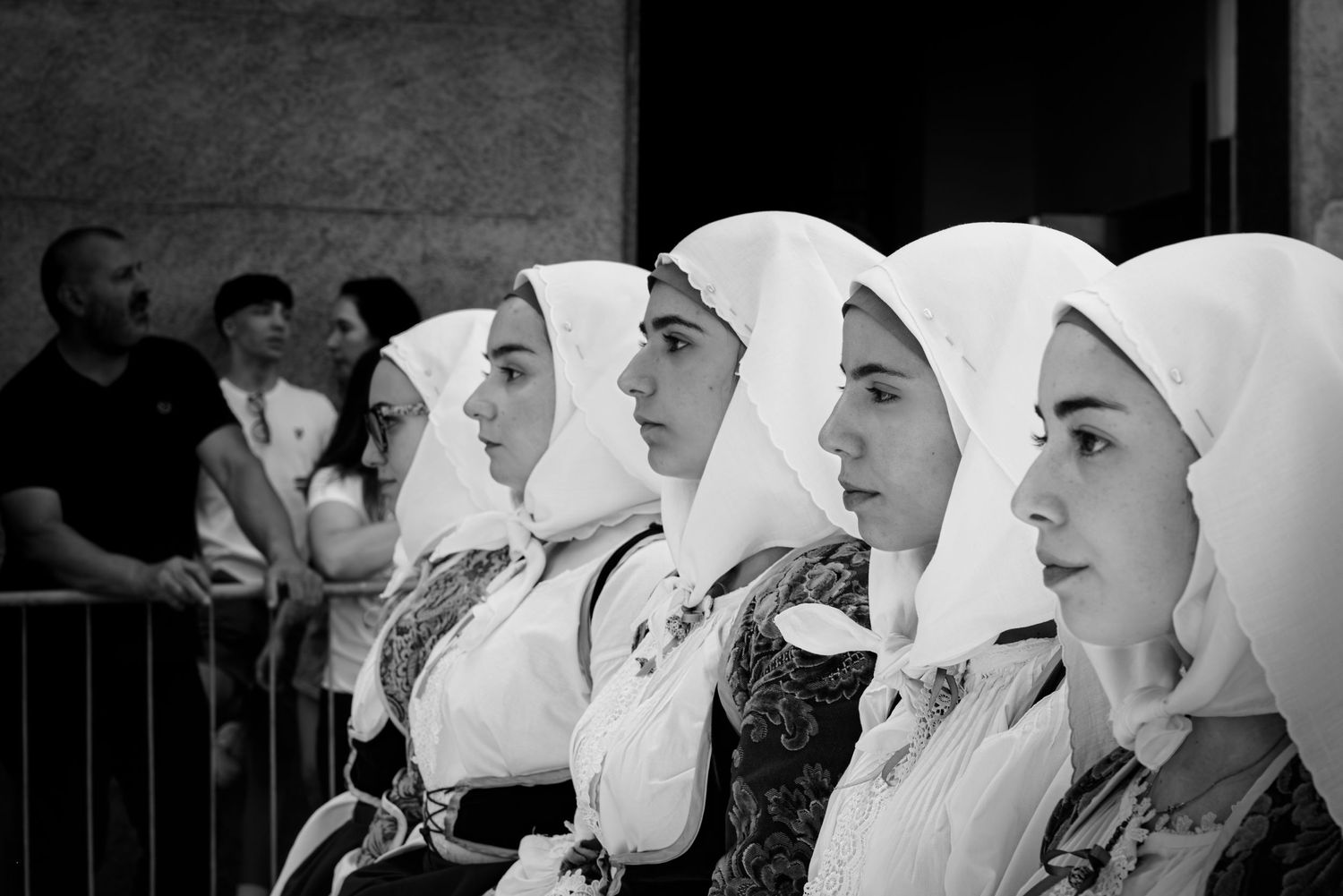 Donne in abito tradizionale sardo in fila di profilo, dettaglio fazzoletti e ricami, sfilata del Redentore - MEvisual