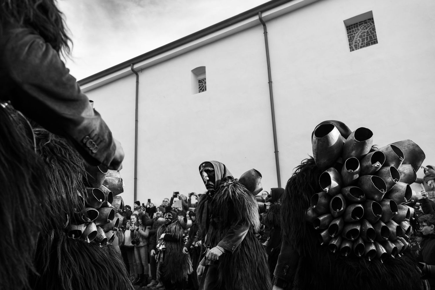Traditional Mamuthones and Issohadores masks around the fire in Mamoiada, Sardinia - Black and white reportage by Marco Eretta