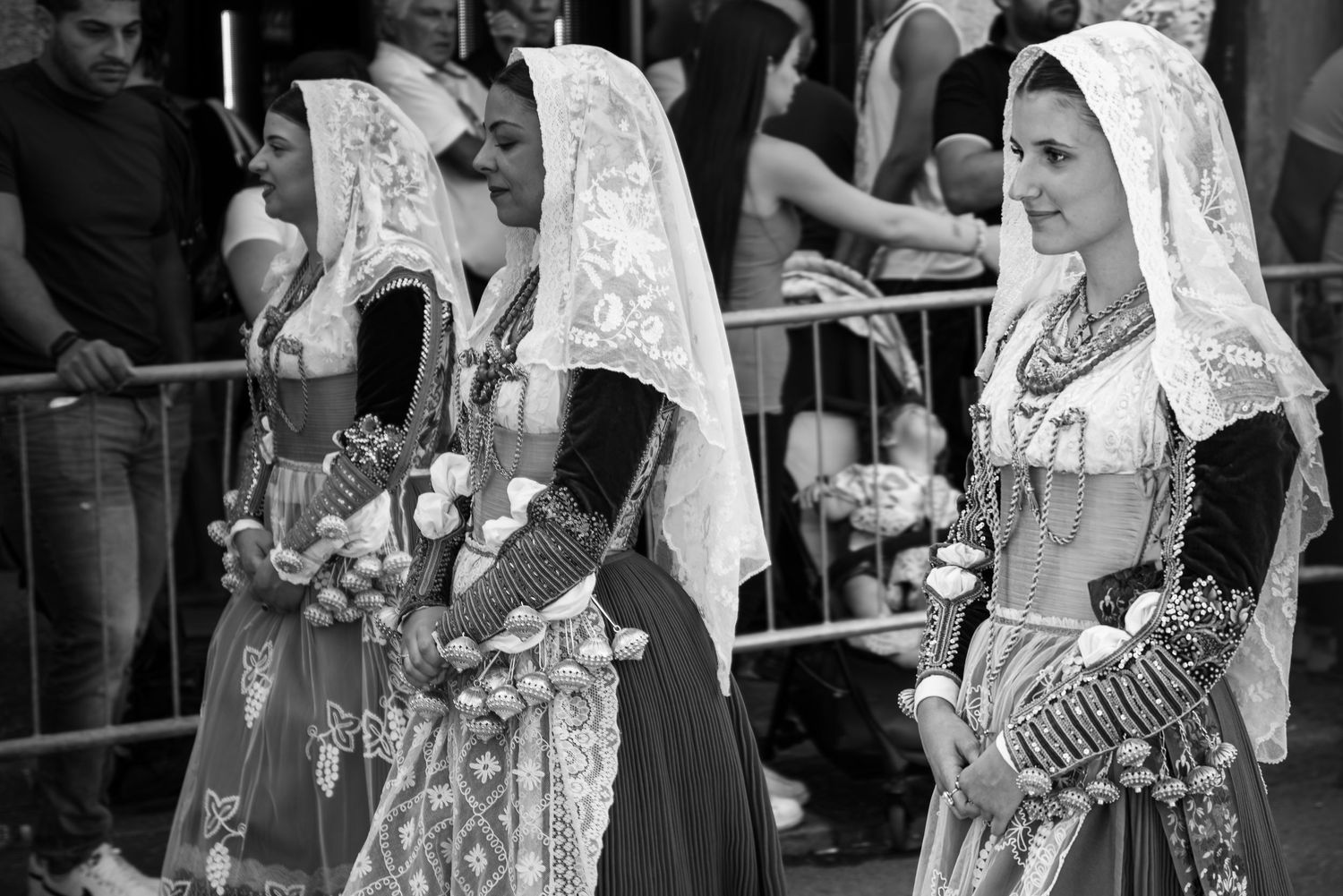 Donne in abito tradizionale sardo in fila di profilo, dettaglio fazzoletti e ricami, sfilata del Redentore - MEvisual