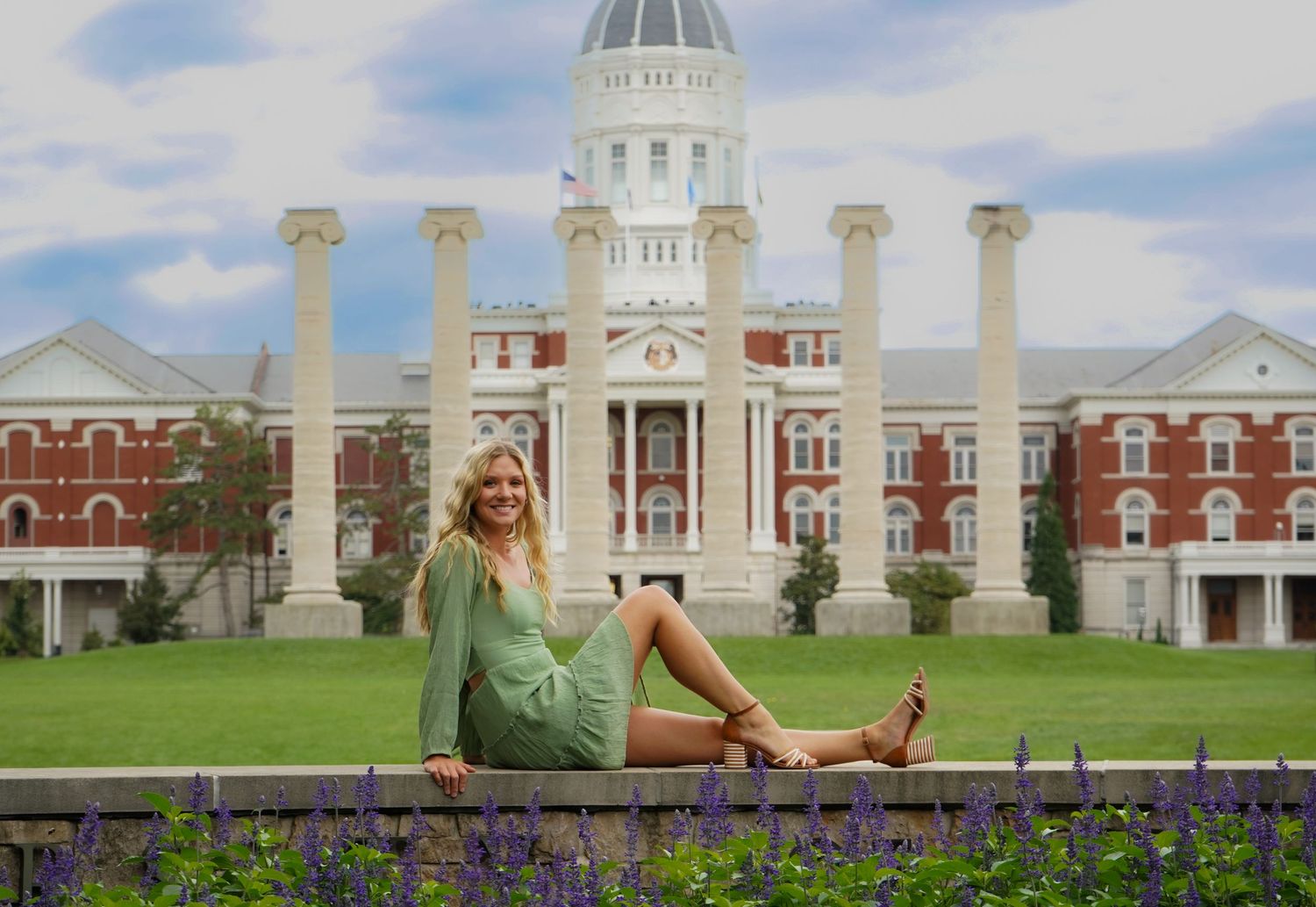 Smiling blonde woman in green dress sitting in front of the Mizzou Columns. Columbia MO, Shelby Renee Studios