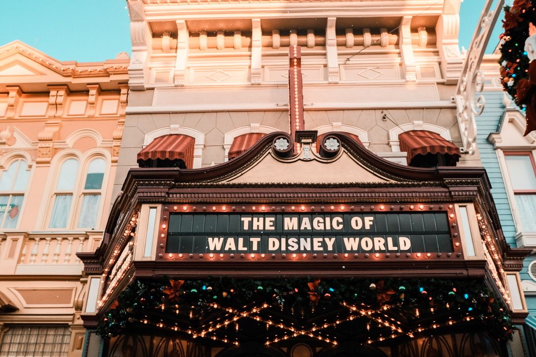Illuminated marquee sign reading The Magic of Walt Disney World on a vintage-style building facade with decorative lights.