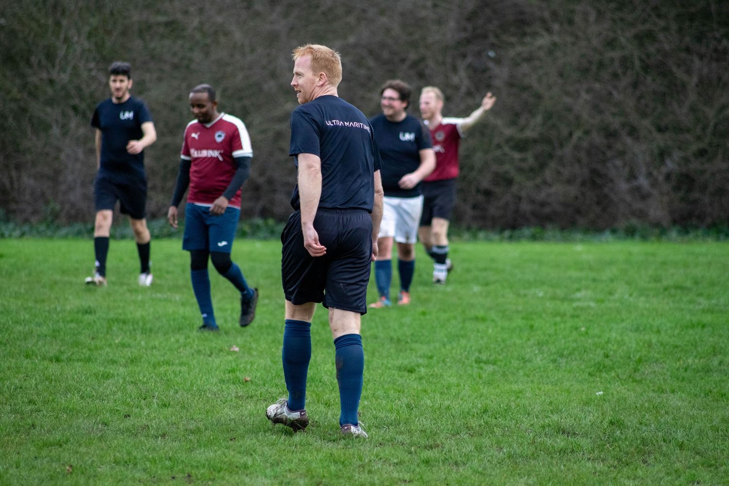 Football players positioning during match with team communication in sports photography in England, UK