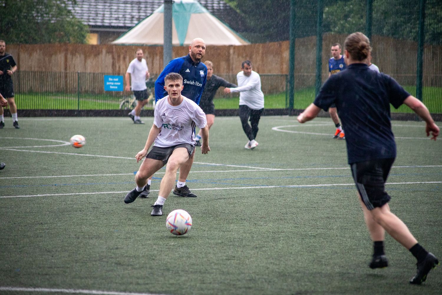 Football player dribbling past opponent during small-sided game in South London, UK