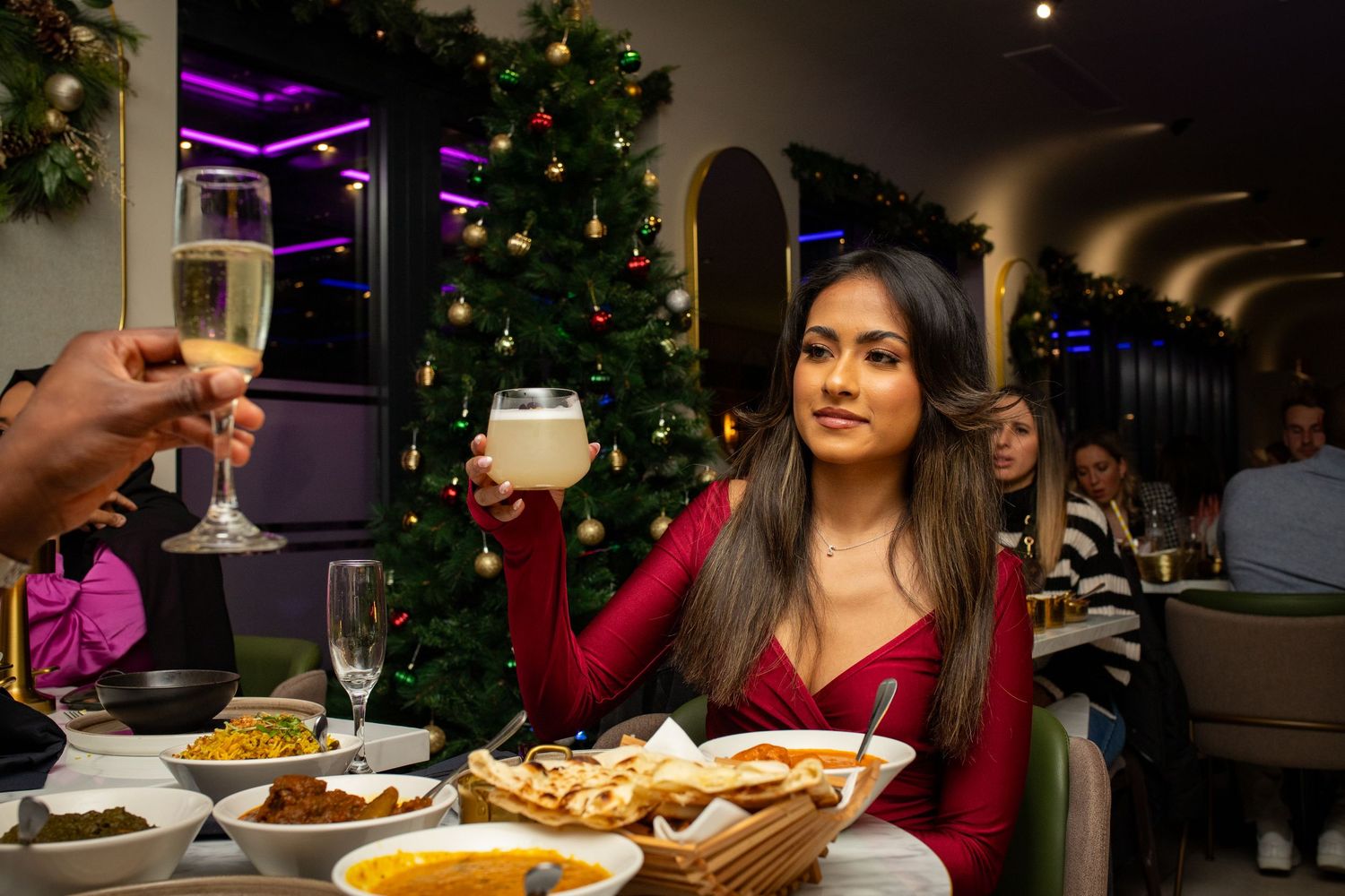 Guest raising glass during restaurant opening celebration with dining atmosphere in Heathrow, London, UK