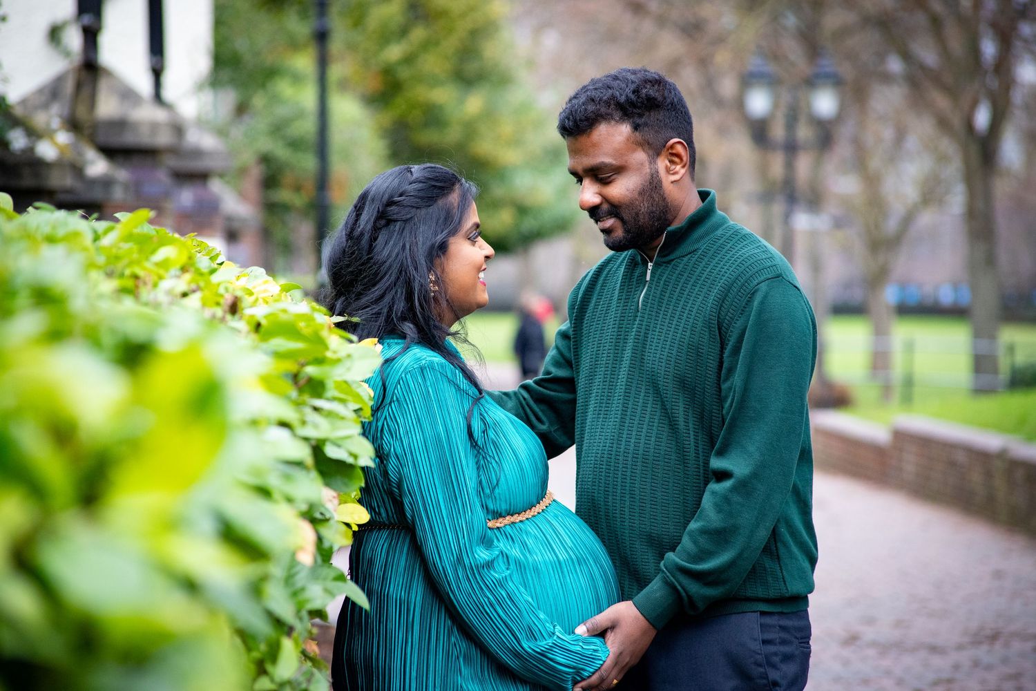 Couple embracing during outdoor maternity photoshoot with natural pregnancy photography in London, UK